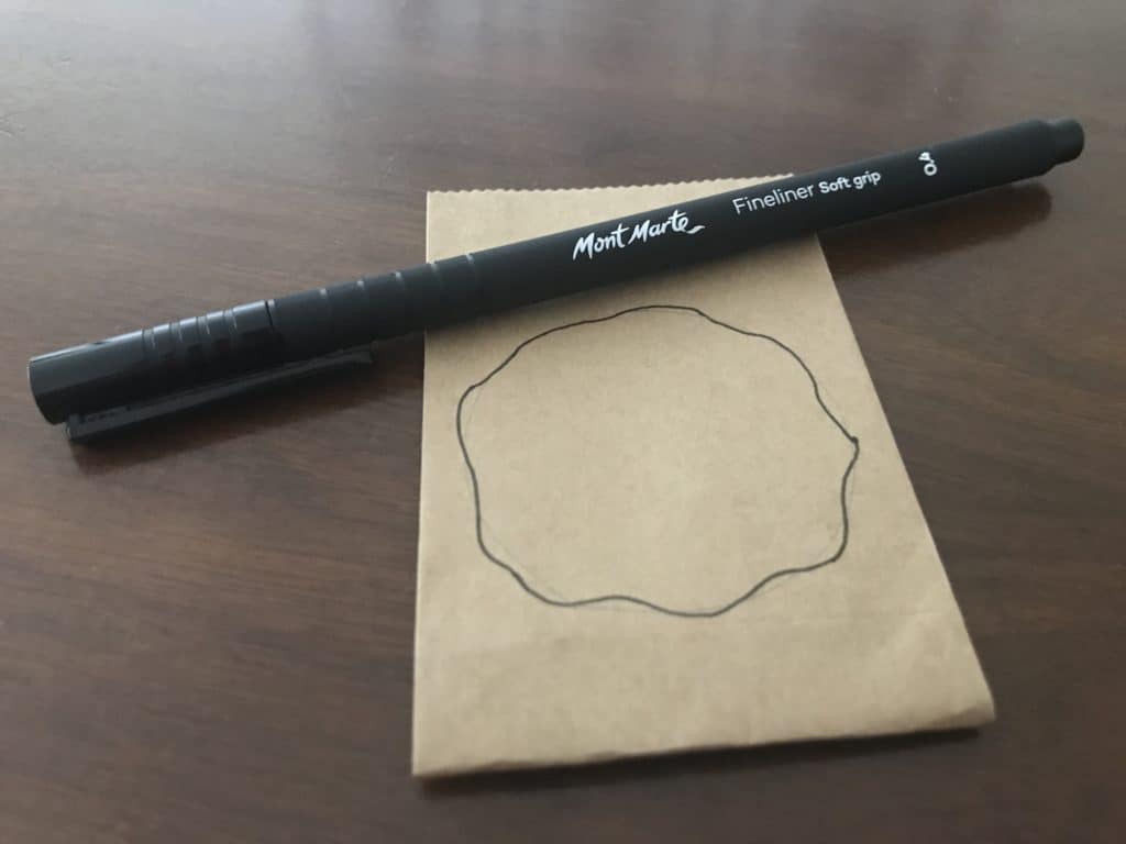 drawing wavy black circle on brown paper bag